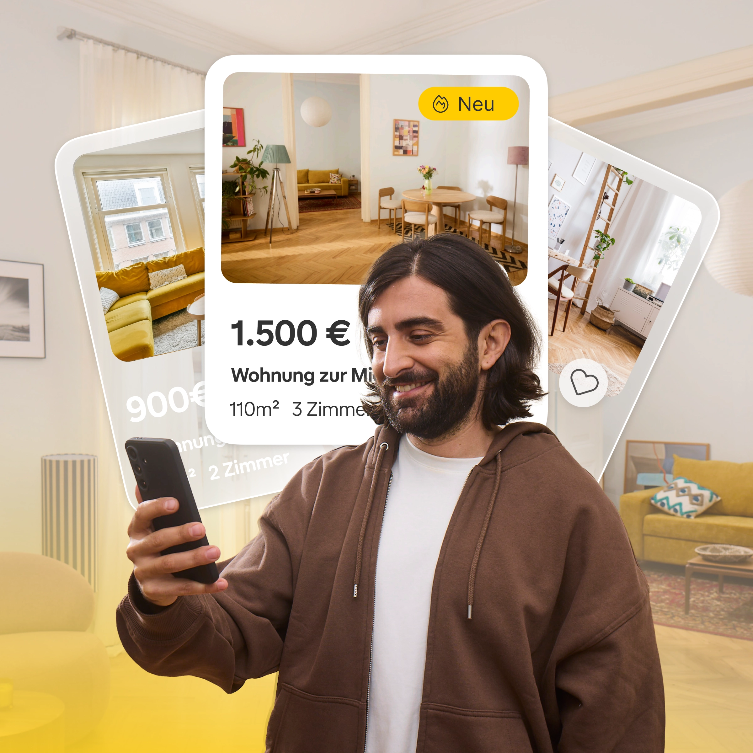 Ein Mann mit Brille und gelbem Hemd lächelt, während er auf sein Smartphone schaut. Im Vordergrund steht eine grüne Tasse auf einem Tisch.