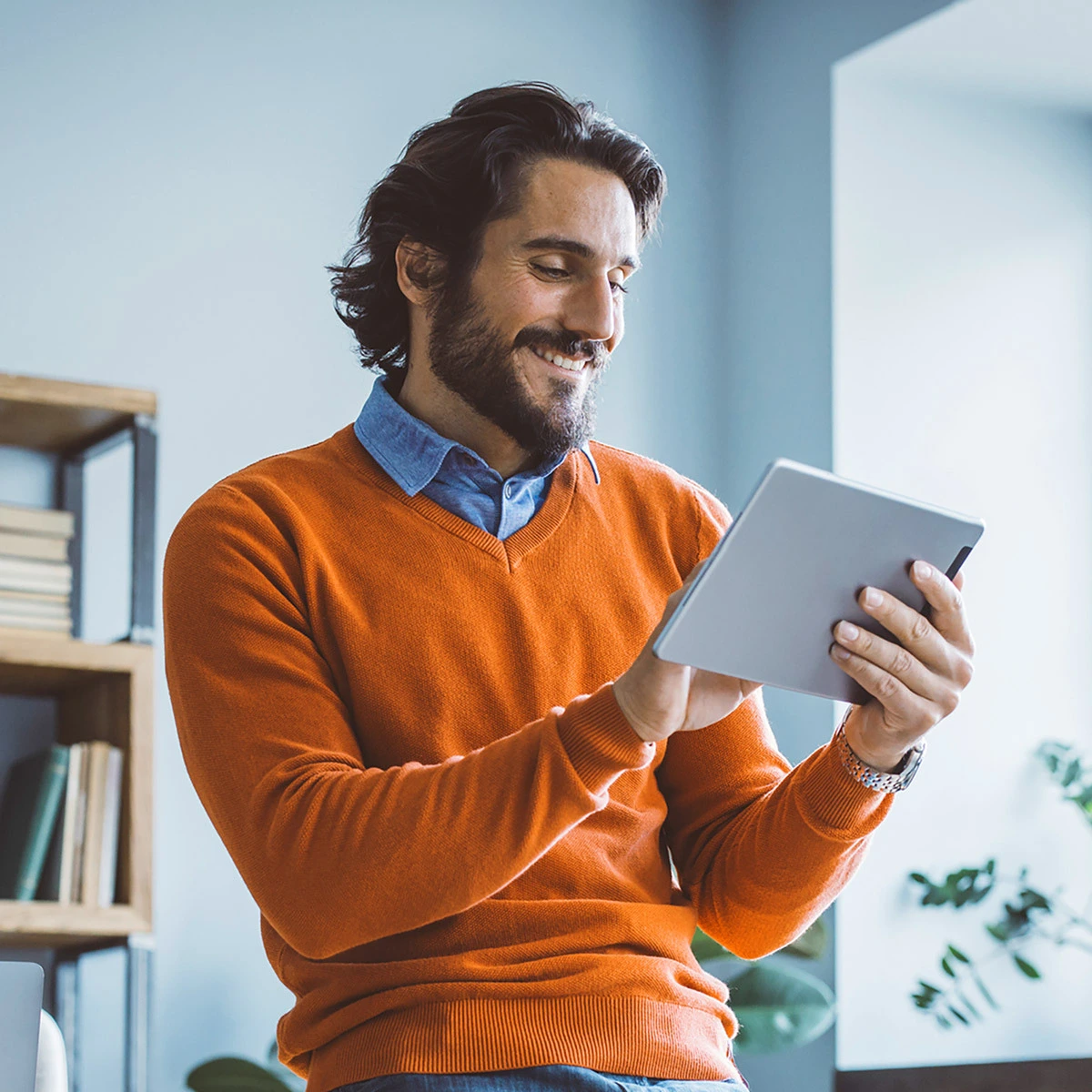 Mann informiert sich am Tablet über Wohnungsverkauf